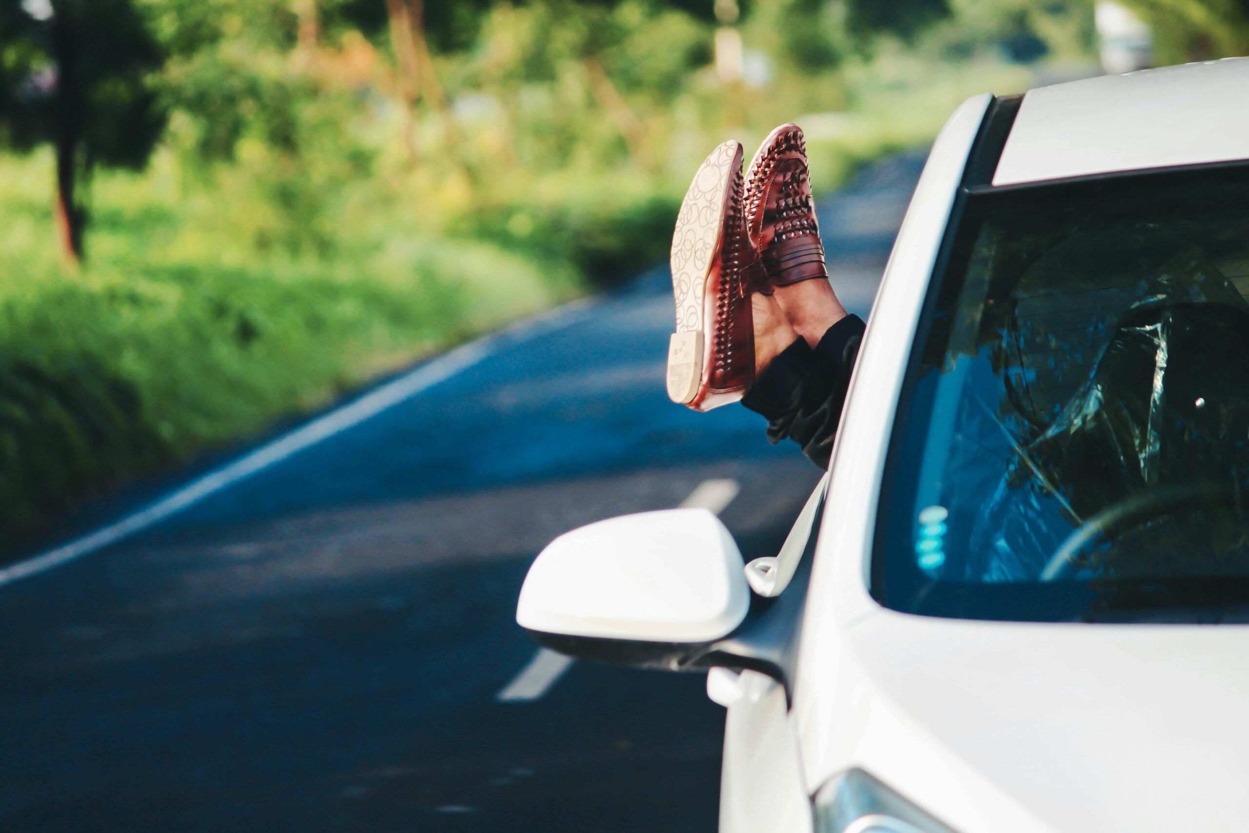 a person's feet sticking out of a car window